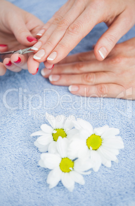 Woman cutting fingernail with scissors