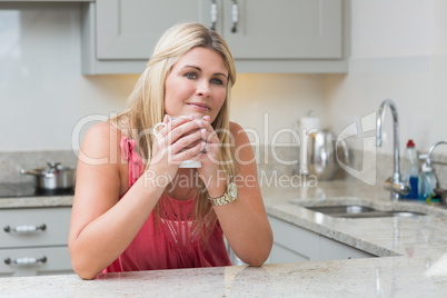 Young woman with coffee cup in the kitchen