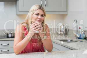 Young woman with coffee cup in the kitchen