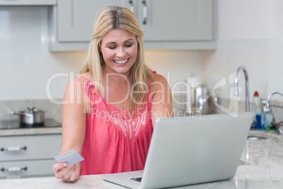 Woman doing online shopping in the kitchen