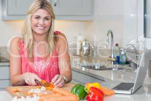 Portrait of woman making recipe from internet on laptop in kitch