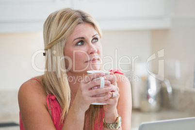 Close-up of young thoughtful woman with coffee cup