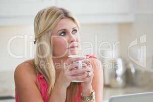 Close-up of young thoughtful woman with coffee cup