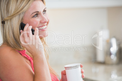 Side view of casual woman with coffee cup using cellphone