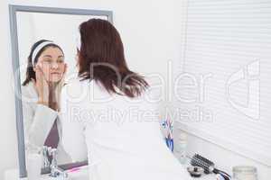 Young woman looking at mirror