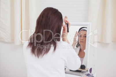 Young woman putting on make-up