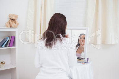 Young woman putting on make-up