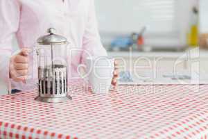 Woman with kettle and coffee cup