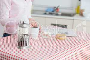 Woman with kettle and coffee cup