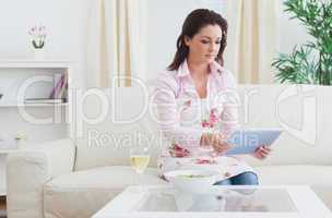 Casual young woman looking at digital tablet on sofa