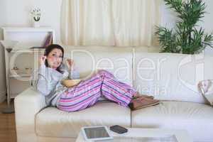 Bored woman having popcorn on couch at home