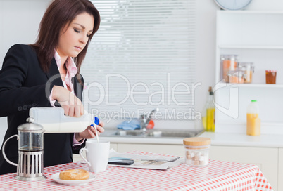 Business woman pouring milk in coffee cup