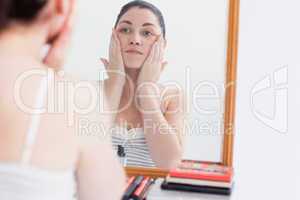 Woman applying cream on face