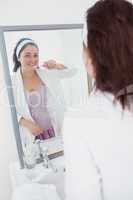 Woman brushing her teeth in the mirror