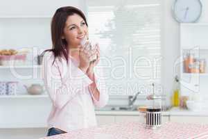 Thoughtful woman drinking coffee in the kitchen