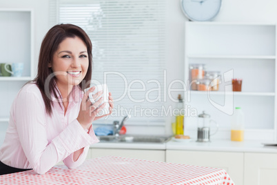 Happy woman with coffee cup in the kitchen