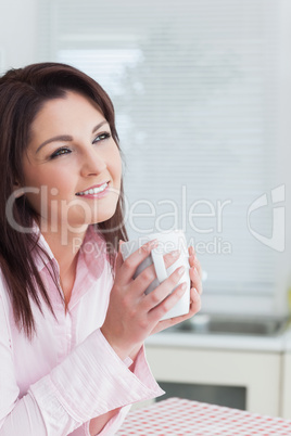 Woman looking away while drinking coffee