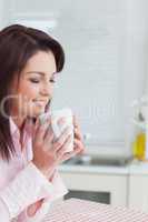 Woman with eyes closed smelling coffee