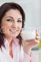 Close-up of young woman with glass of milk