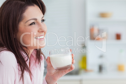 Side view of woman with glass of milk