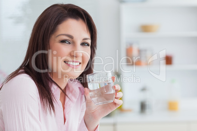 Close-up portrait of woman with glass of water