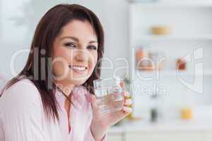 Close-up portrait of woman with glass of water