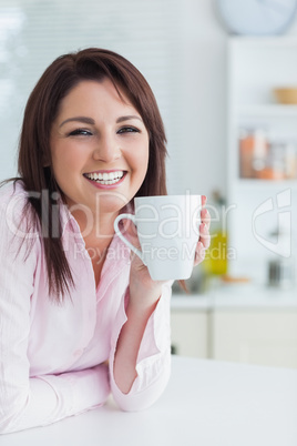 Young woman with coffee cup in the kitchen