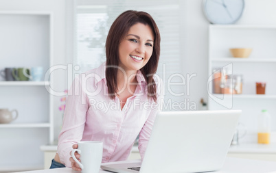 Portrait of woman with coffee cup and laptop