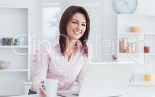 Portrait of woman with coffee cup and laptop