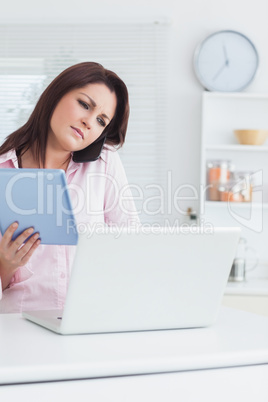 Woman on call while using digital tablet and laptop