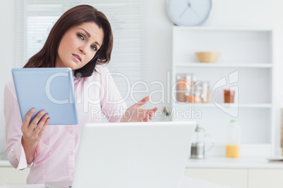 Woman on call while using digital tablet and laptop