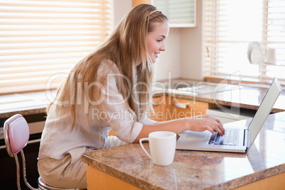 Young woman using laptop in the kitchen