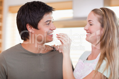 Woman feeding vegetable to man