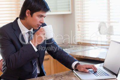 Business man using laptop while drinking coffee