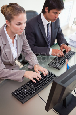 Business colleagues using computers in office