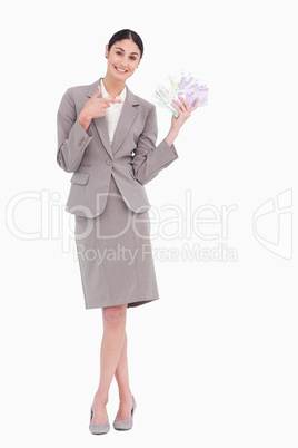 Portrait of happy business woman pointing at banknotes