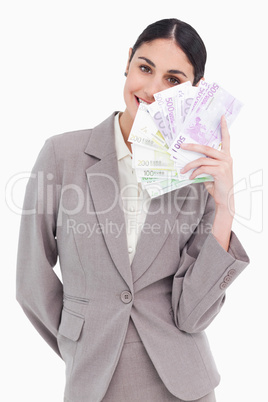 Portrait of happy business woman holding fanned banknotes