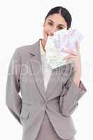 Portrait of happy business woman holding fanned banknotes