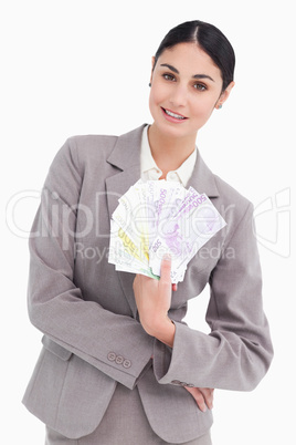 Portrait of business woman holding fanned banknotes