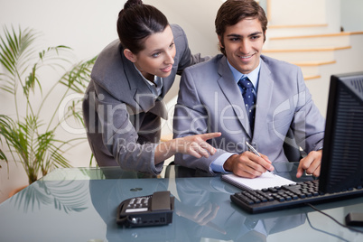 Colleagues looking at computer screen at office