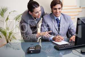 Colleagues looking at computer screen at office