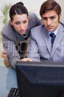 Colleagues looking at computer screen in office