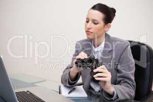 Business woman with binoculars looking at laptop