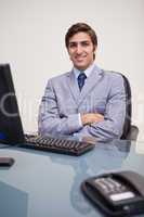 Portrait of business man sitting in front of desktop computer