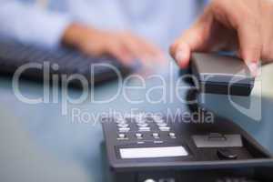 Man with telephone receiver at desk