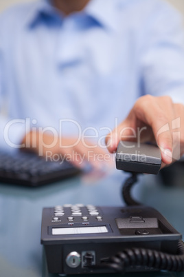 Close-up of man with telephone receiver at desk