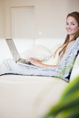 Portrait of casual woman using laptop on couch