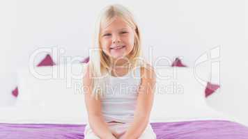 Cute girl sitting on a double bed