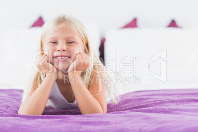 Little girl lying on a double bed