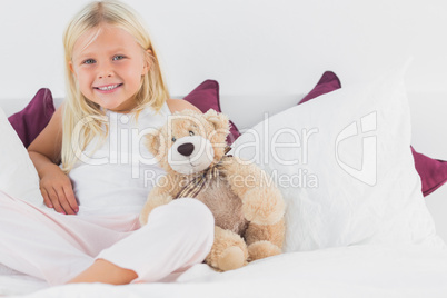 Little girl sitting near to her teddy bear